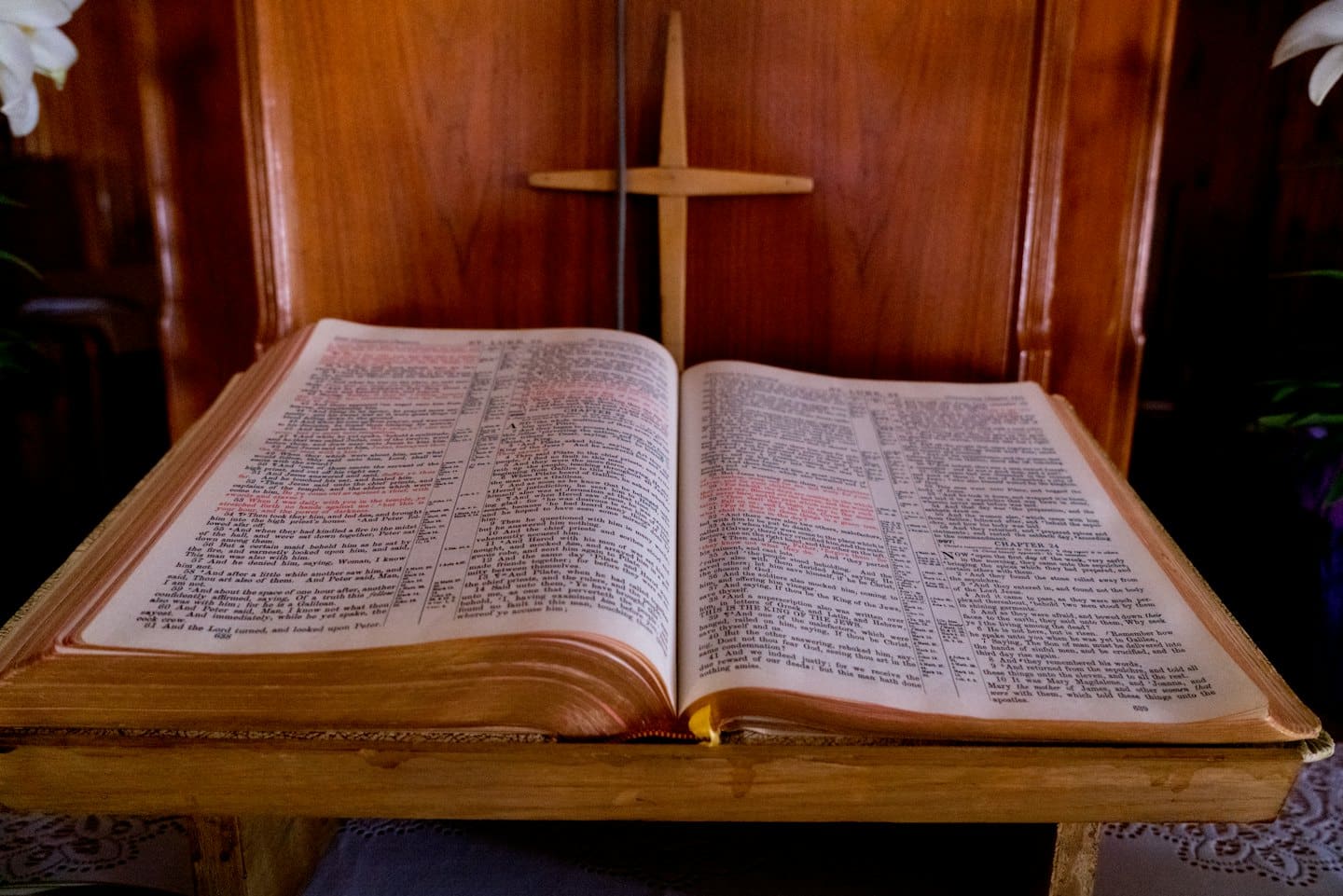 Bibbia aperta su un leggio di legno con una croce di legno.