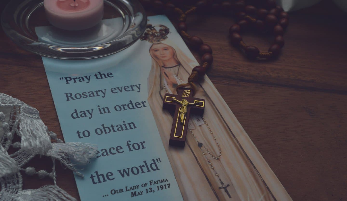 Oggetti religiosi tra cui un santino, un crocifisso e un rosario.